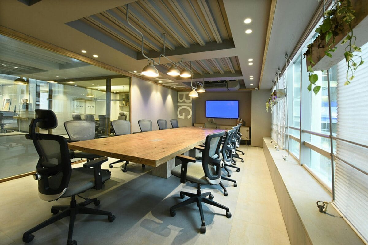 A spacious and modern conference room featuring glass walls, sleek furniture, and a bright, open atmosphere, ideal for meetings and discussions.