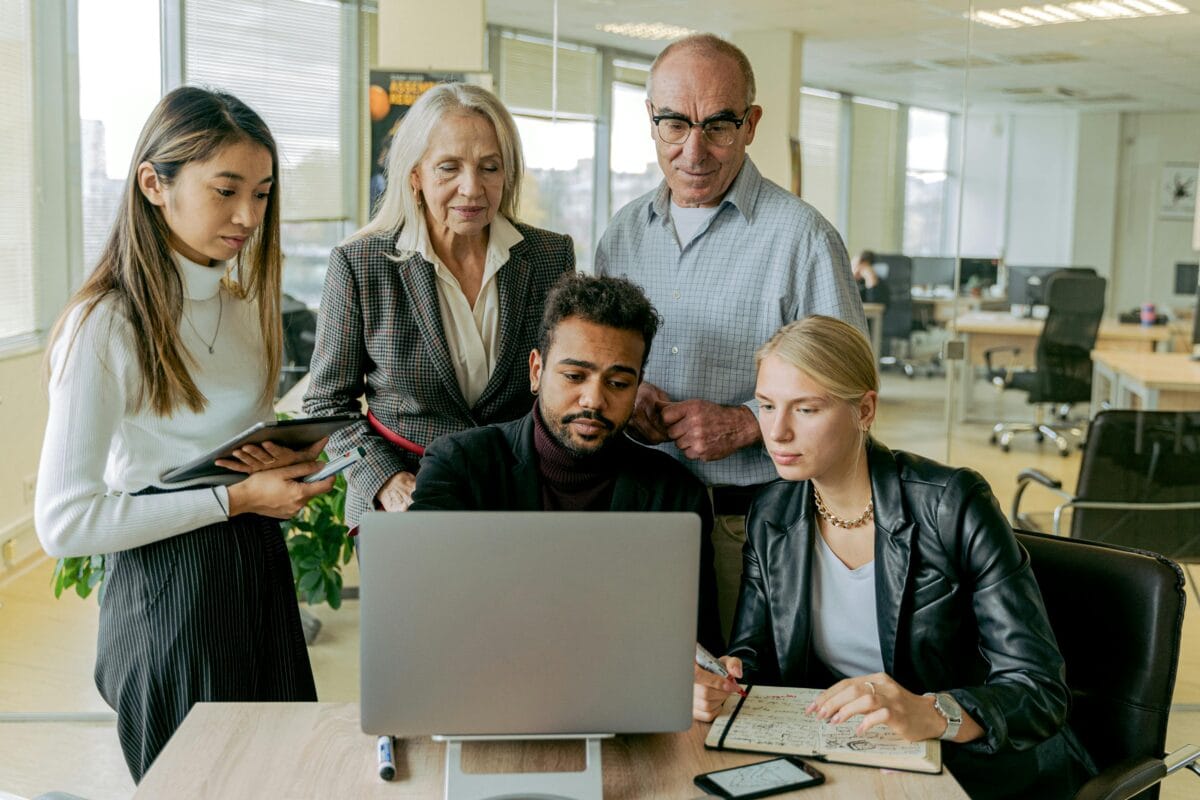 A team of colleagues collaborating in the office, discussing ideas and working together around a table in a productive and modern workspace.